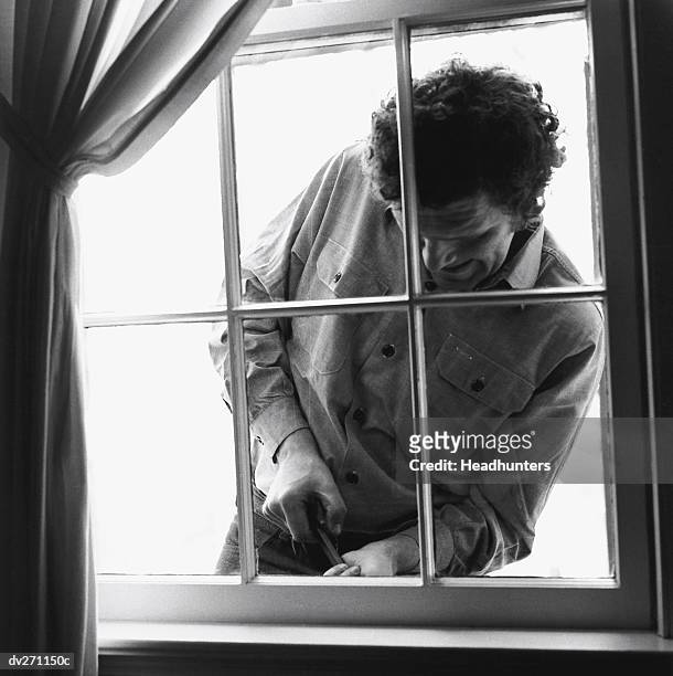 burglar trying to enter home via window - via stock pictures, royalty-free photos & images