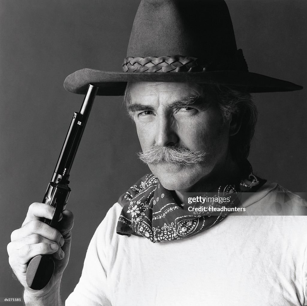 Cowboy holding gun to hat