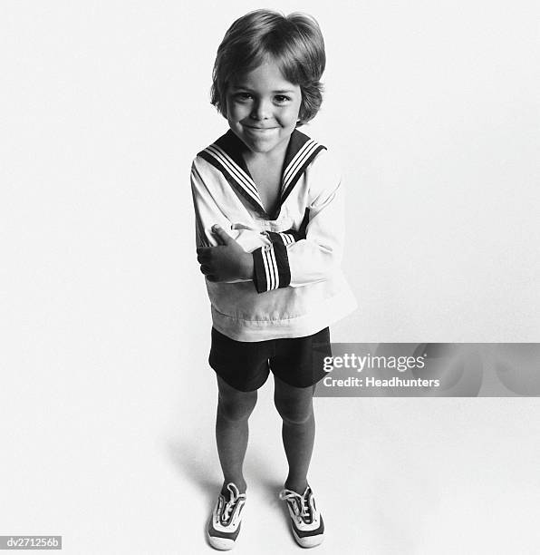 overhead view of boy in sailor suit, arms crossed - headhunters stock-fotos und bilder