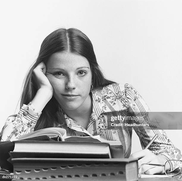 young woman leaning on hand, writing - headhunters stock-fotos und bilder