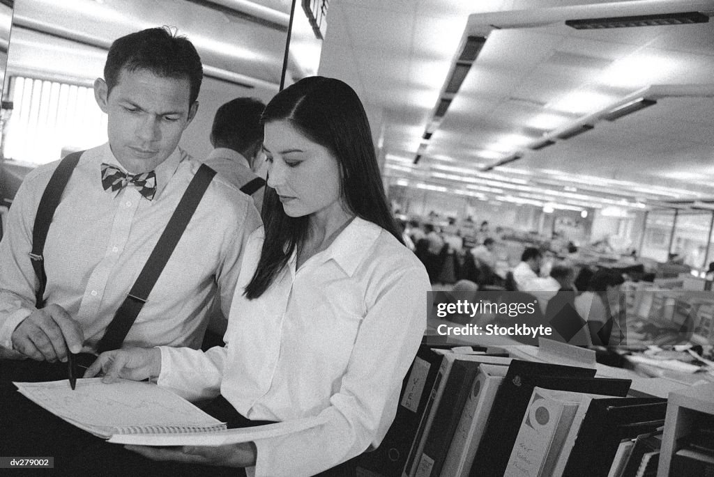 Businessman and businesswoman looking over paperwork