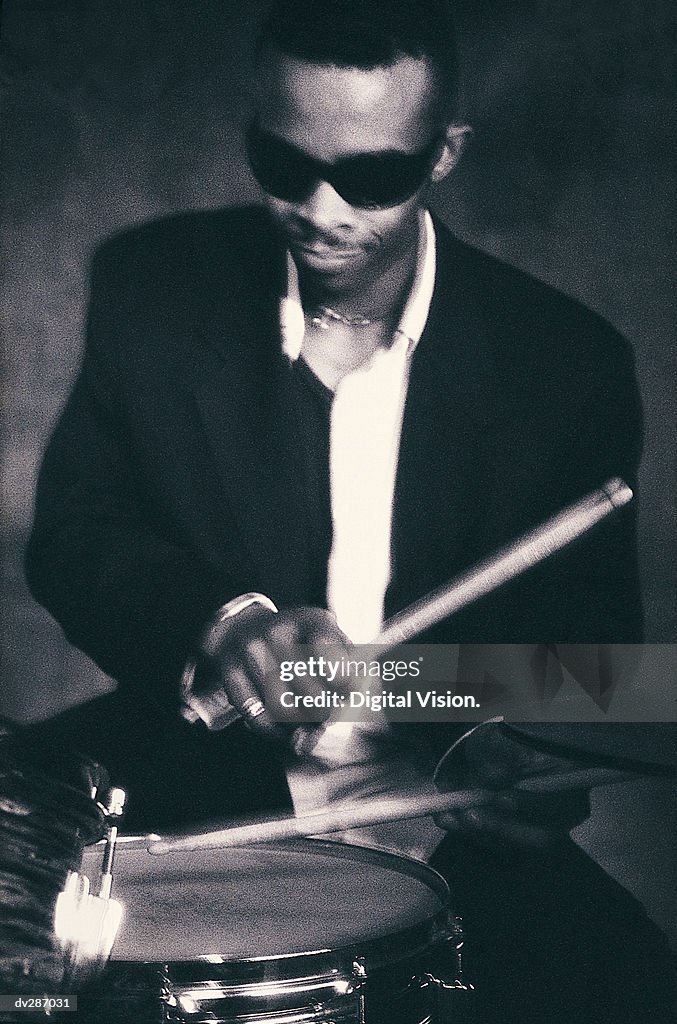 Drummer in dark glasses playing snare