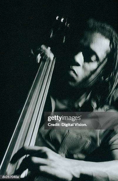 man looking down while playing double bass - strings section stock pictures, royalty-free photos & images