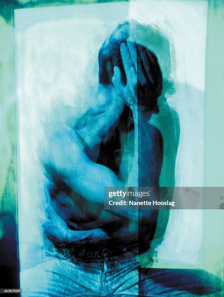 Man sitting with hand to head
