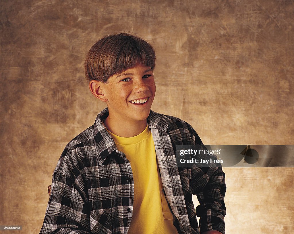 Smiling boy in yellow t-shirt and plaid shirt