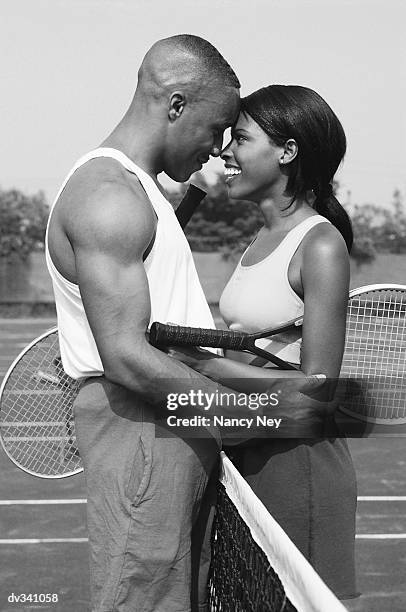 couple embracing at tennis court - tennis court stock pictures, royalty-free photos & images