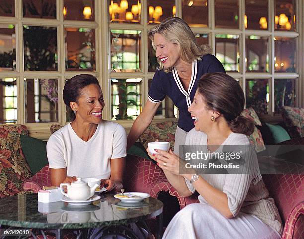 three women having tea together - kaffeeklatsch stock-fotos und bilder