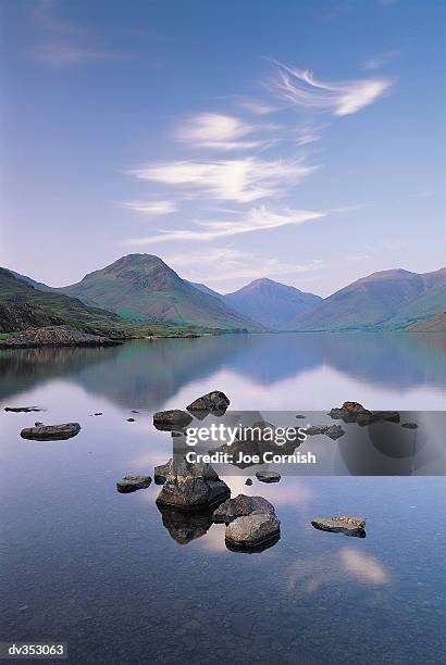 rocks in lake surrounded by mountains - cumbrian mountains stock pictures, royalty-free photos & images