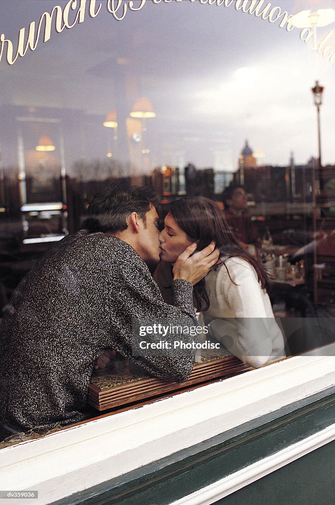 Couple kissing in restaurant window