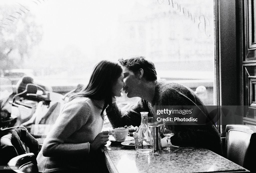 Couple kissing over coffee
