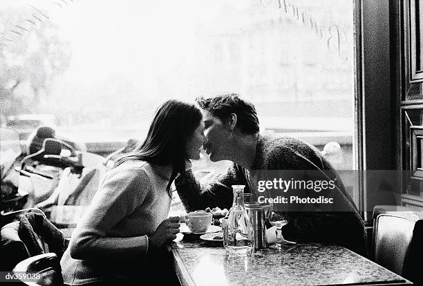 couple kissing over coffee - black and white couple stock pictures, royalty-free photos & images