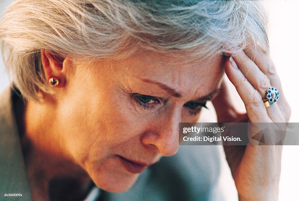 Worried businesswoman resting head in hand