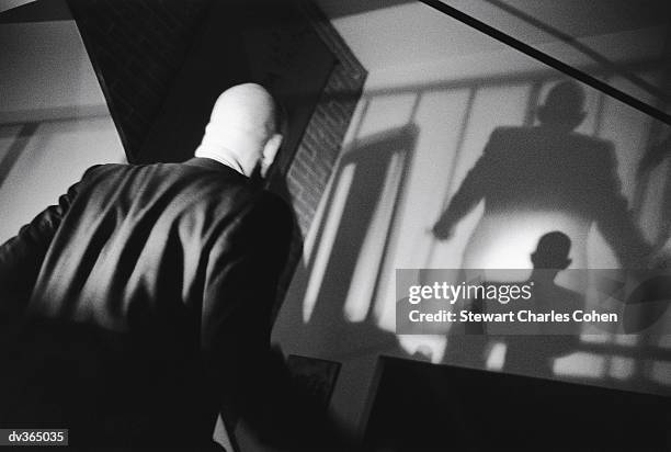 back of man with shadows on wall - stewart stock-fotos und bilder