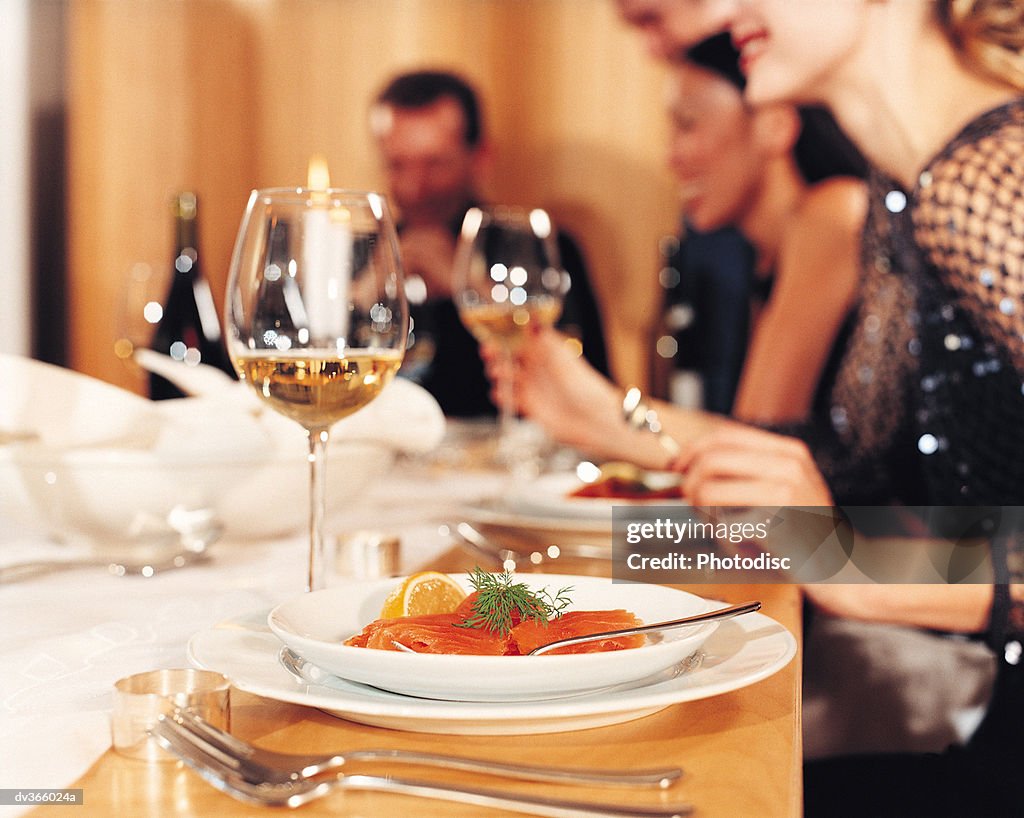 Close-up of dinner setting with salmon and wine