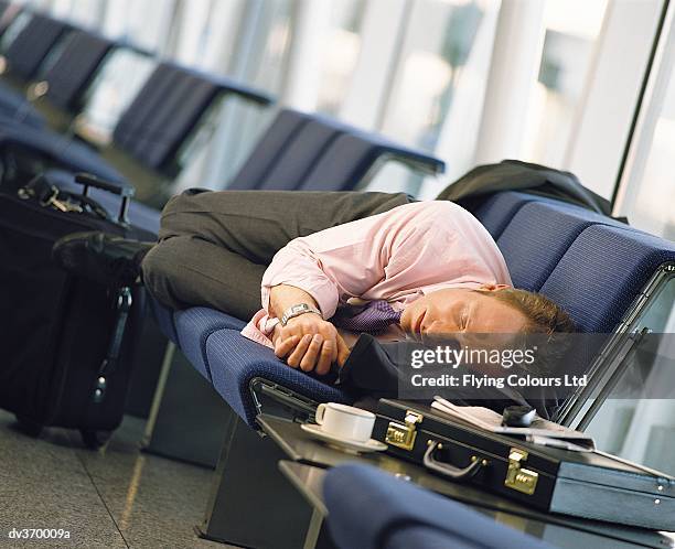 napping businessman at airport - jetlag stock-fotos und bilder