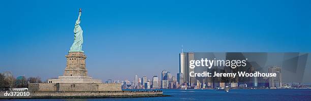 statue of liberty with manhattan in background - manhattan foto e immagini stock