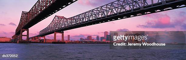 bridge over mississippi river, new orleans in background - new orleans bridge stock pictures, royalty-free photos & images