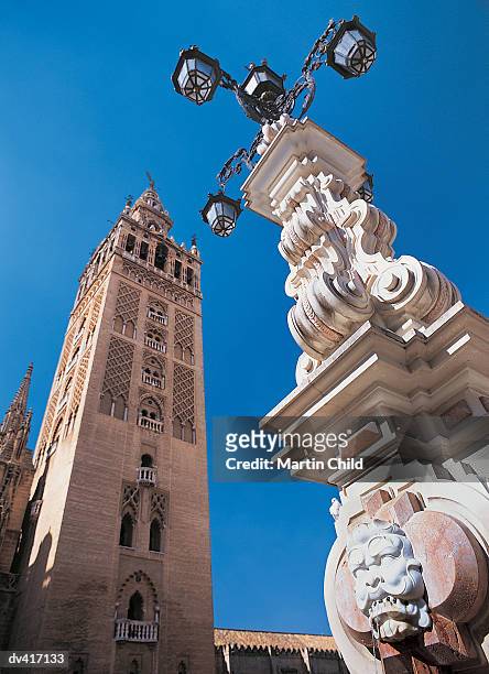 fountain and la giralda bell tower, plaza de los reyes, santa cruz, seville, spain - seville cathedral stock pictures, royalty-free photos & images