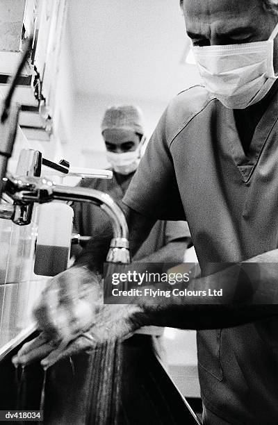 surgeon washing hands - schoonschrobben stockfoto's en -beelden