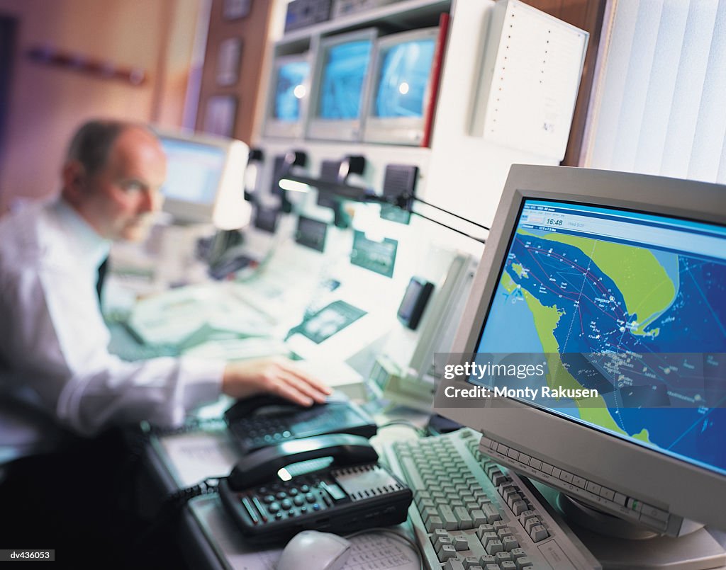 Meteorologist studying weather pattern on computer screens