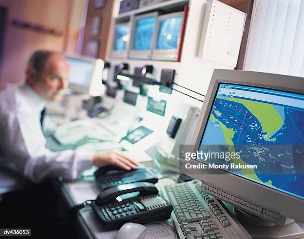 meteorologist studying weather pattern on computer screens - meteorología fotografías e imágenes de stock