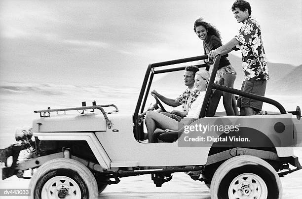 four friends driving on a beach - fahrspaß stock-fotos und bilder