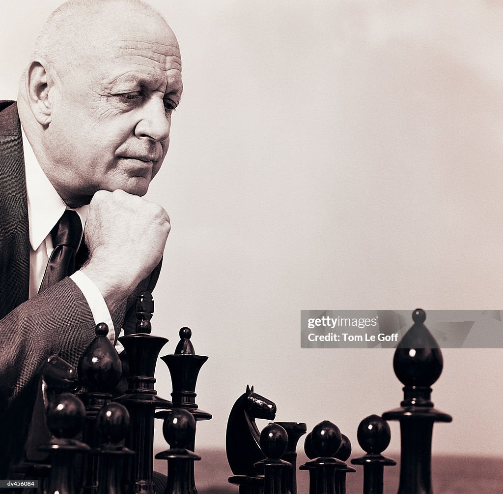 Businessman pondering chess move