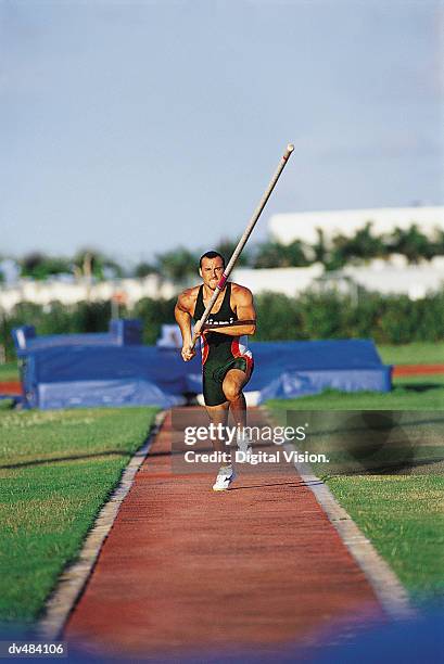 pole vaulter running with pole - mens field event 個照片及圖片檔