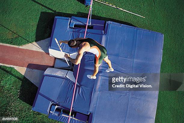 pole vaulter going over bar - mens field event 個照片及圖片檔
