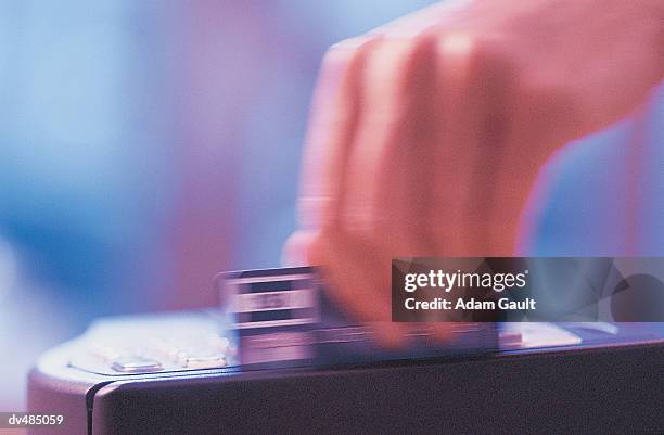 hand swiping credit card through credit card reader - grano fuerte fotografías e imágenes de stock