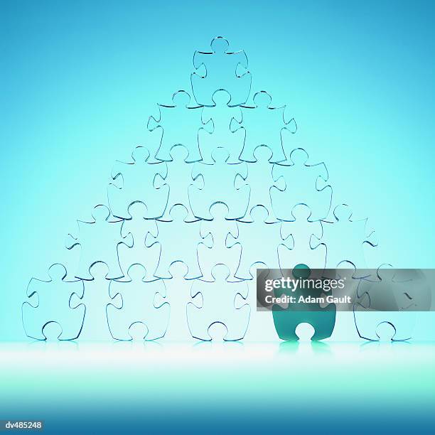 jigsaw puzzle pieces arranged in a human pyramid - dernière pièce du puzzle photos et images de collection