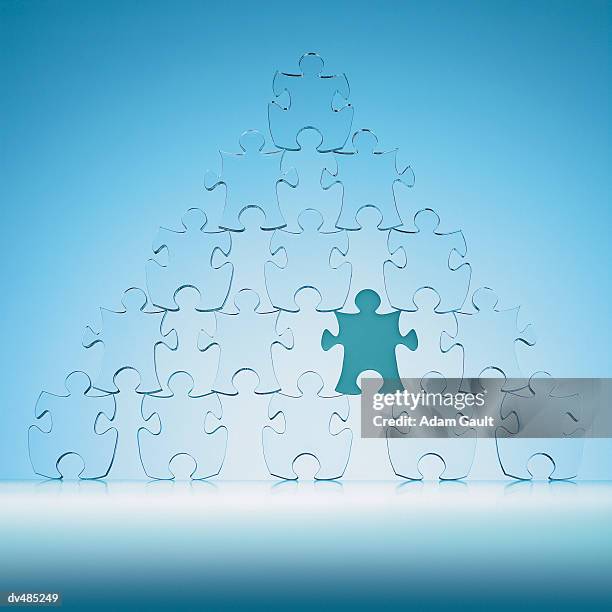 jigsaw puzzle pieces in a pyramid shape - dernière pièce du puzzle photos et images de collection