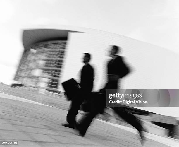 running businessmen - candid black and white corporate stock pictures, royalty-free photos & images