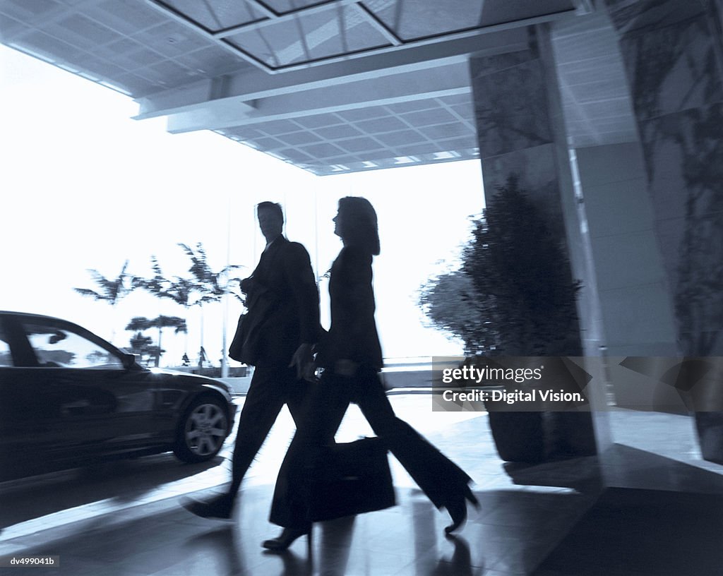 Silhouetted Businesspeople Heading Towards Car