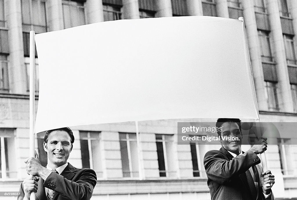 Two businessmen holding a blank banner