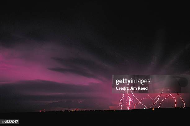 lightning against purple night sky - forked lightning stock pictures, royalty-free photos & images