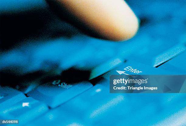 close up of a finger above the enter key on a computer keyboard - tecla enter fotografías e imágenes de stock