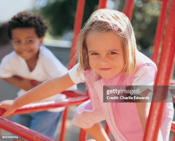 girl playing on jungle gym - jungle gym stockfoto's en -beelden