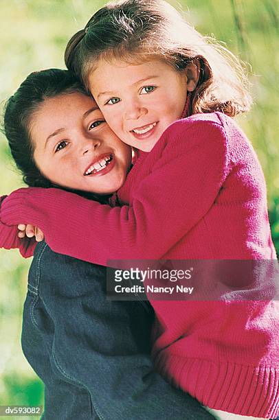 young girl's hugging each other - nancy green stock-fotos und bilder