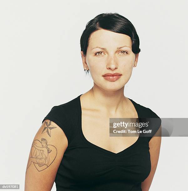portrait of a young woman with tattooed arm - le ストックフォトと画像