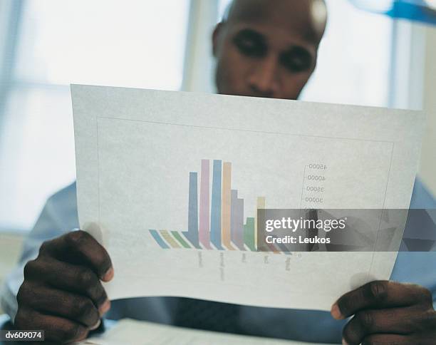 businessman looking at bar graph - bar graph stockfoto's en -beelden