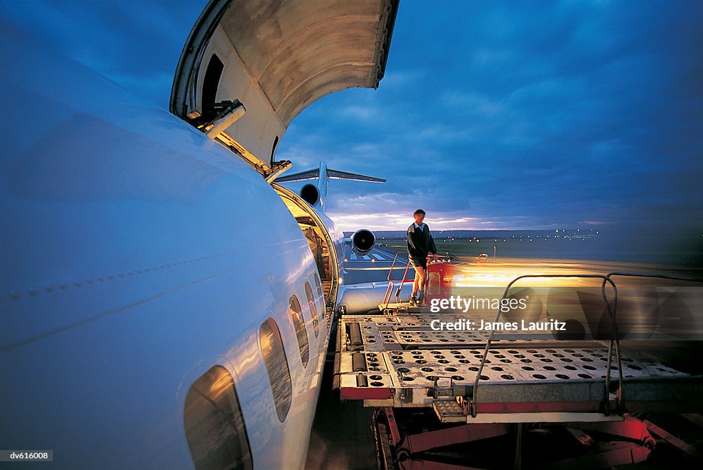 Worker Loading Cargo on Airplane