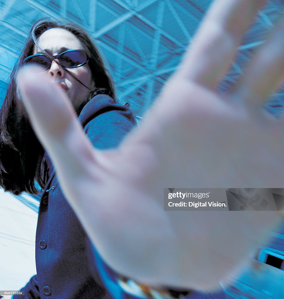 Businesswoman Blocking Camera with Hand