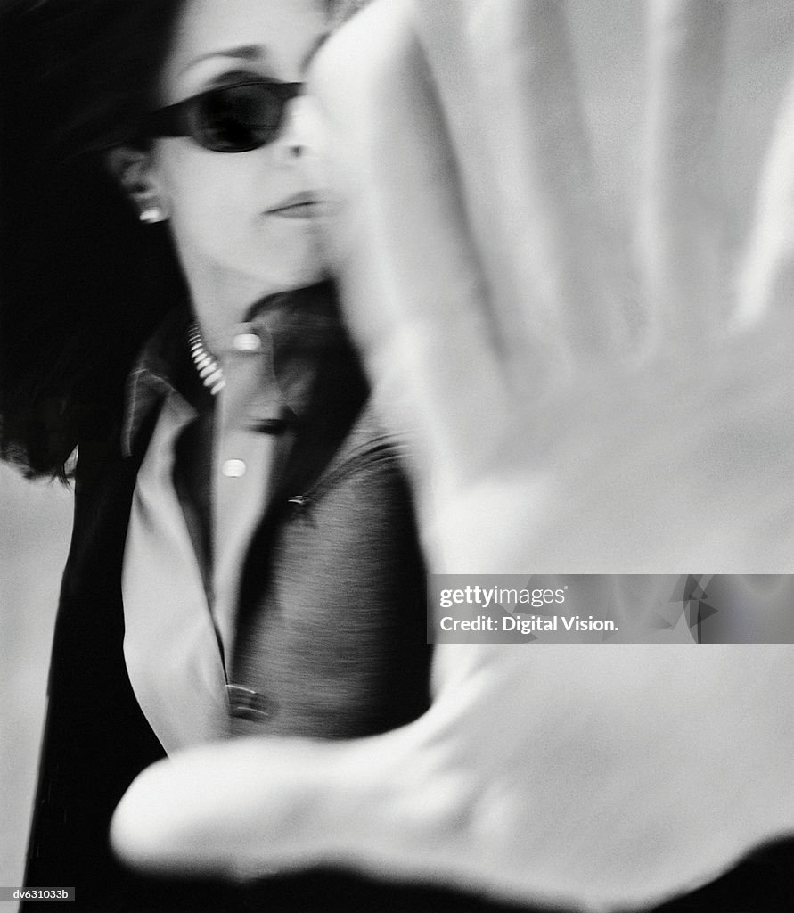 Businesswoman Blocking Camera with Hand