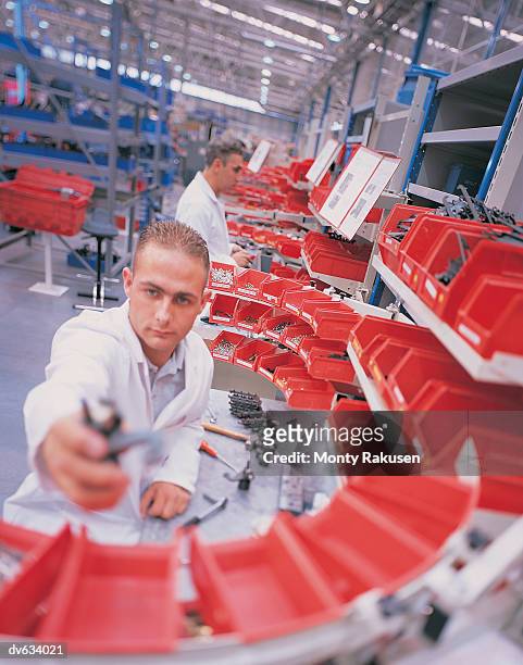 workmen working in a machine assembly factory - monty rakusen stock-fotos und bilder