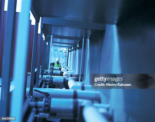 workman checking pipes at factory - monty rakusen stock pictures, royalty-free photos & images