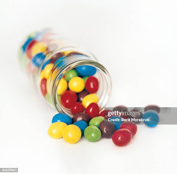 jar of candy coated chocolate - candy jar stock pictures, royalty-free photos & images