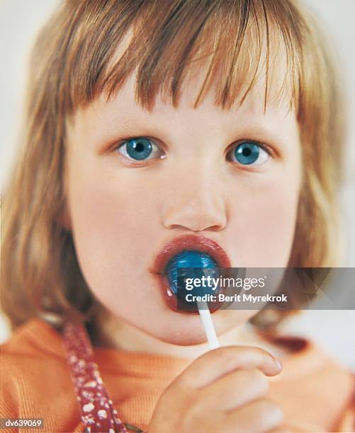 young girl enjoying blue lollipop - super sensory stock pictures, royalty-free photos & images