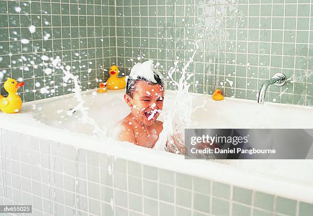 boy splashing in a bath - taking a bath stock-fotos und bilder