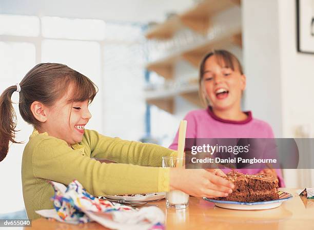 two girls eating cake - daniel fotografías e imágenes de stock